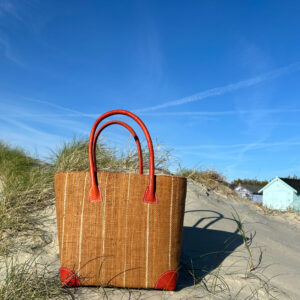 Medium Hanta Pinstripe Tote Bag in cinnamon at the seaside beside beach huts