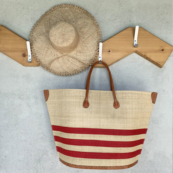 Red stripe Bato Marine Basket with Frayed Summer Hat hanging on coat hooks