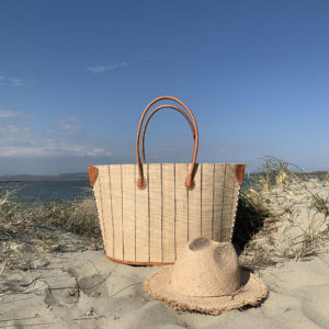 Natural frayed fedora hat with natural pinstripe bato basket at the beach