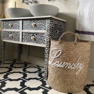 Laundry basket with letters embroidered in bathroom