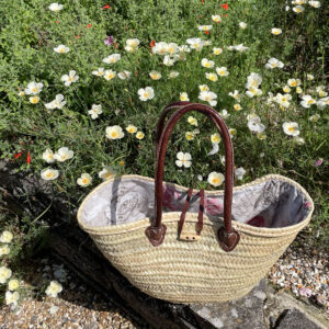 Long handle rose patterned lined basket in a garden