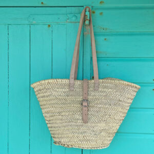 Long handle buckle basket bag hanging on a beach hut