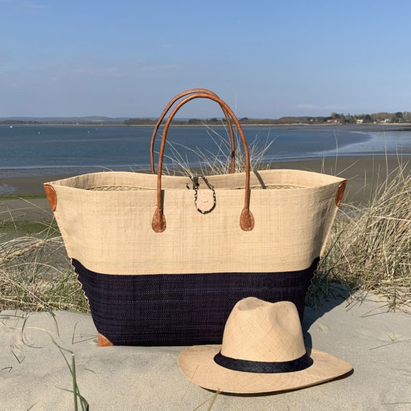 Mery button natural and black beach basket with matching Panama hat beside the sea