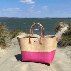 Mery Button Basket Bag in natural and pink on a beach