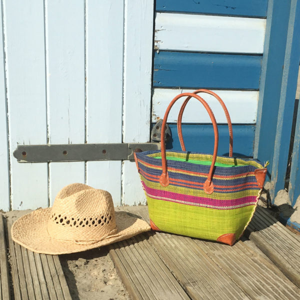 Lime green mery zip handbag with stripes and a cowboy summer hat at the beach