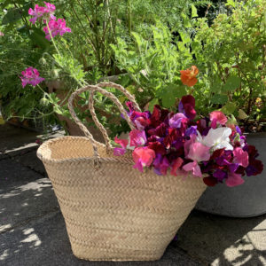Palm handle basket filled with sweet pea flowers
