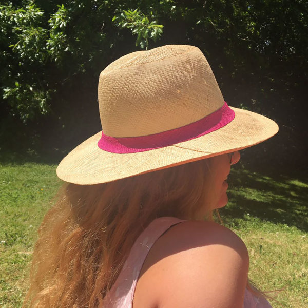 Panama hat with a pink band being worn in the sunshine