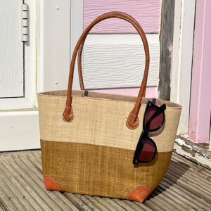 Small Hanta Two Tone Basket Bag in natural and tan beside a beach hut