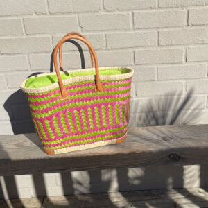 Small lime and pink drawstring shopper on a bench in the sunshine