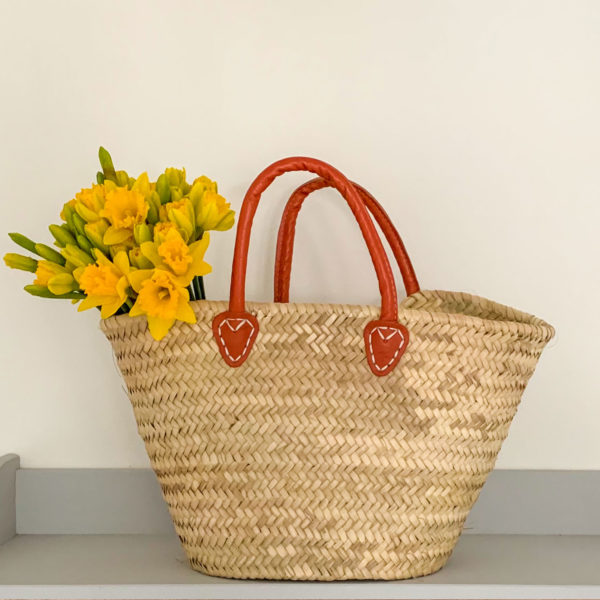 Small orange handle basket with daffodills