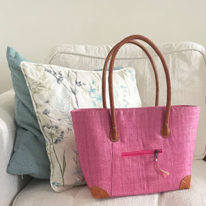 Small pink raffia Vero handbag on a sofa