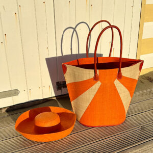 Orange sunburst raffia bag at beach with orange mimosa hat