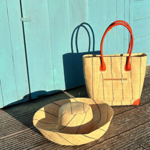 Vero Handbag and Mimosa Hat in natural pinstripes by a beach hut