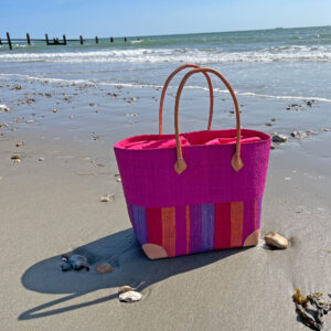 Large Hanta Stripe Raffia Basket Bag in pink stripes at the beach