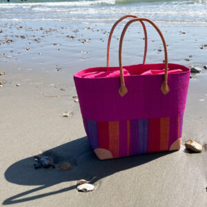 Large Hanta Stripe Basket Bag in pink beside the sea