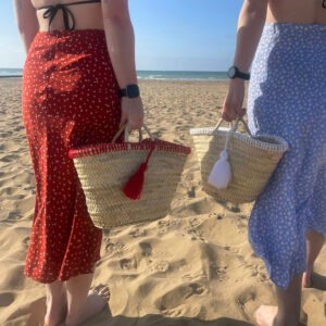 Red and white tassel little rope baskets on the beach