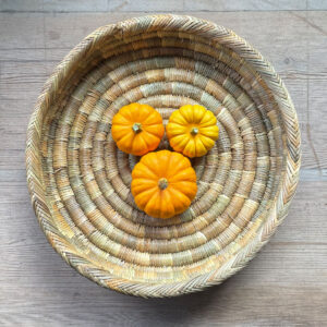 Handwoven round plate tray with mini pumpkins