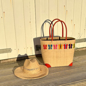 Embroidered tote bag with butterflies and a raffia cowboy hat at the beach