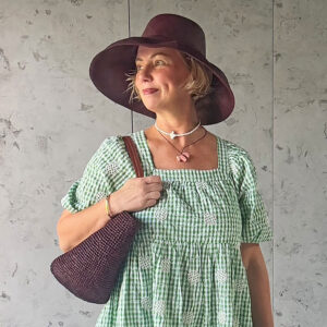 Chocolate crochet drawstring bag with matching Mimosa Hat modelled by Lisa