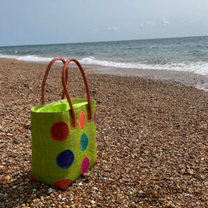 Medium lime circles tote bag at the seaside