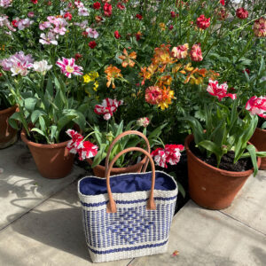 Natural and navy diamond sisal basket bag amongst flowers