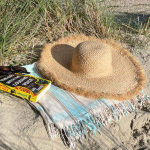 Frayed raffia brim summer hat on the beach