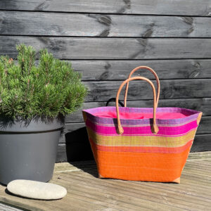 Mery drawstring basket in orange in a garden