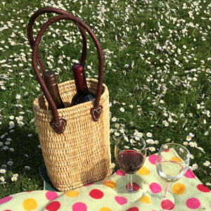 Two bottle basket filled with wine at a picnic