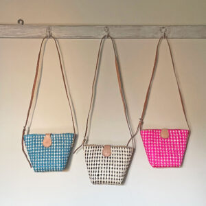 PlusPlus Crossbody Handbag available in 3 colours, hanging on a wall hooks
