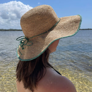 Crochet colour rim hat in turquoise worn at beach