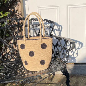 Crochet circles bag in black on an iron bench in the sunshine