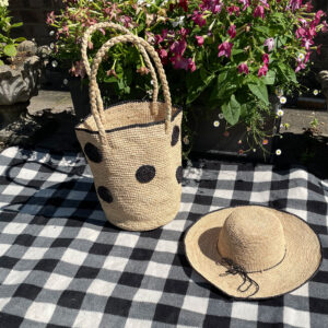 Black crochet circle bag and black rim crochet hat on picnic blanket