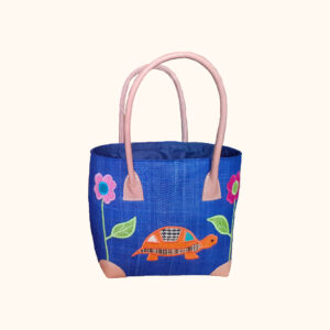 Small size tote bag with embroidered tortoise and flowers on one side with a navy background cut out photo