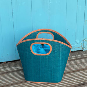 Toky raffia handbag in turquoise beside a beach hut