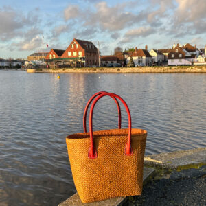 Camille raffia tote bag in cinnamon beside a pond
