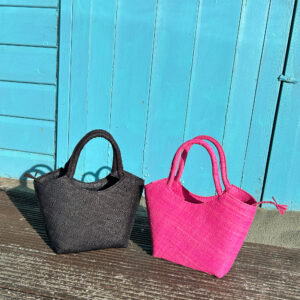 Lillie Handbag in black and pink beside beach hut
